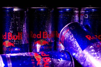 Close-up of Red Bull cans with water droplets, showcasing a refreshing and energetic vibe.